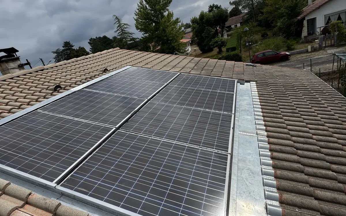 Toiture en tuiles canal avec panneaux solaires et bande métallique de raccord sur le côté