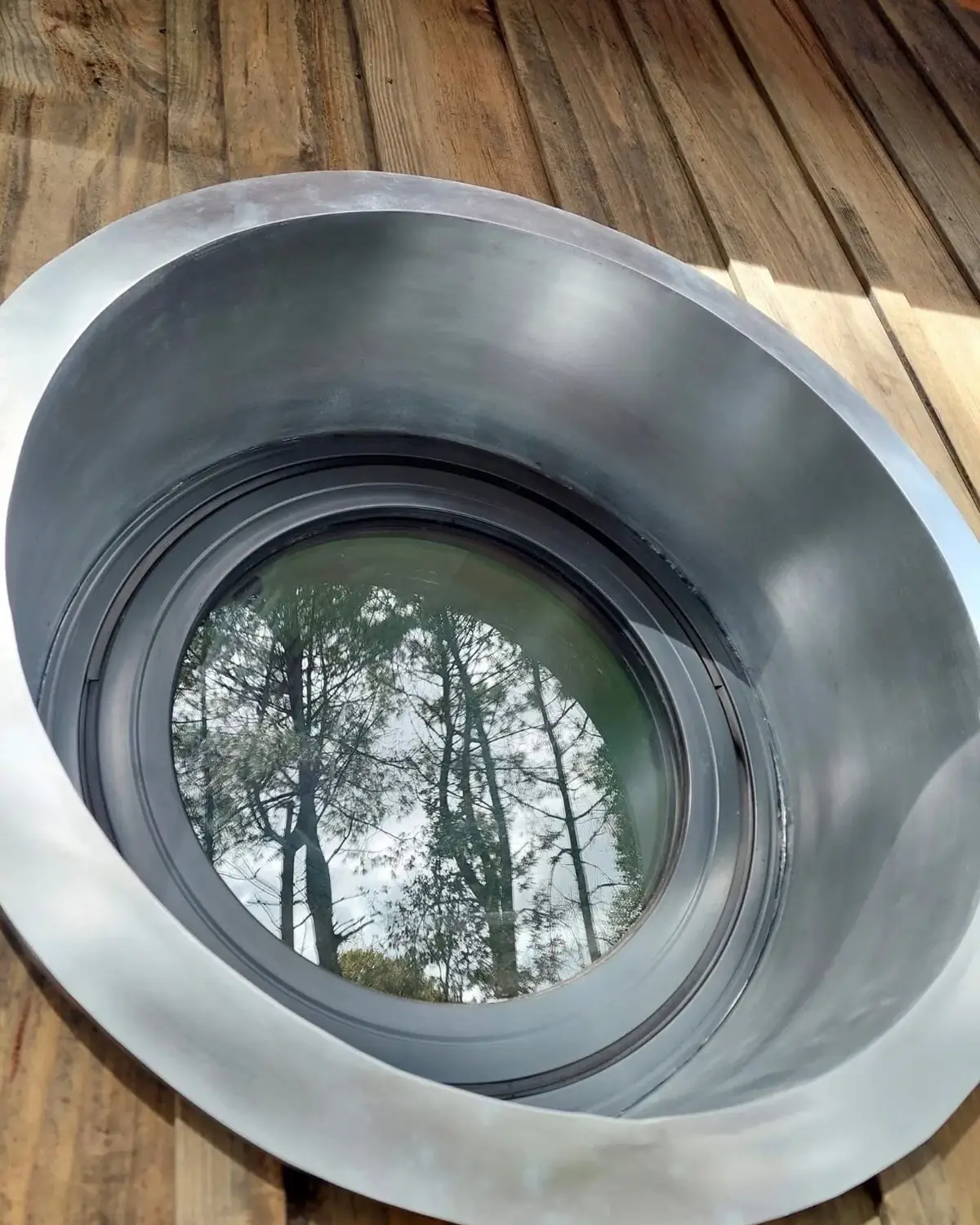 Œil-de-bœuf en zinc sur une toiture en bois