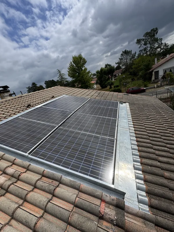 Panneaux solaires intégrés à un toit de tuiles canal, avec une bande de métal gris le long du côté