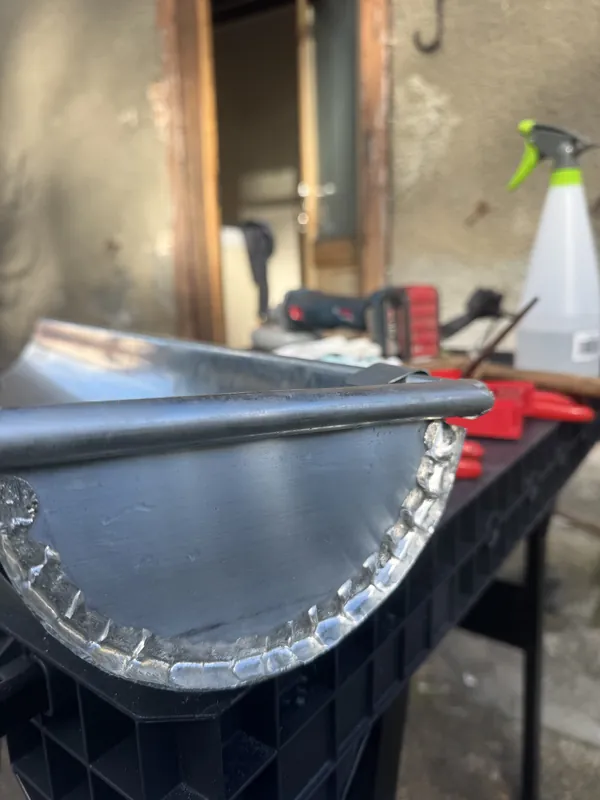 Gouttière demi-ronde sur un établi, avec son fond soudé sur tout le contour